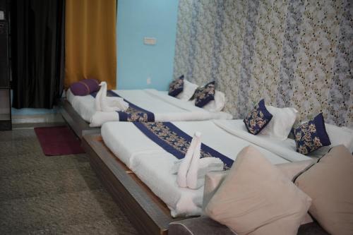 una fila de camas alineadas en una habitación en Panambi Tapovan Resort, en Rishīkesh