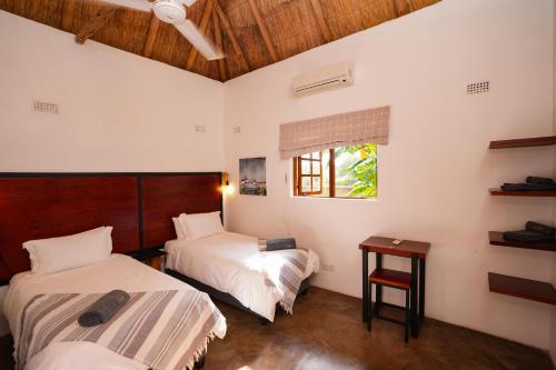 a bedroom with two beds and a window at 2 bed apartment with pool - 2126 in Victoria Falls