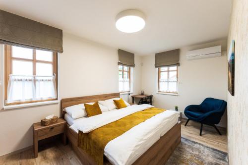 a bedroom with a large bed and a blue chair at Penzion Nad Pavlovem in Pavlov