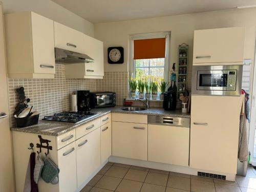 a kitchen with white cabinets and a stove top oven at Villa Mina in Bad Bentheim