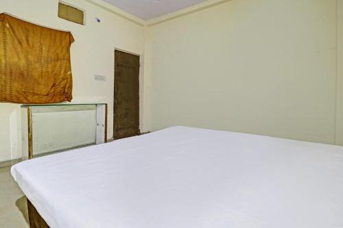 a white bed in a room with a window at SPOT ON 81062 Moonlight Hotel in Bhilai