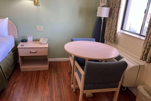 a small room with a table and a bed at Travelodge by Wyndham Holbrook in Holbrook