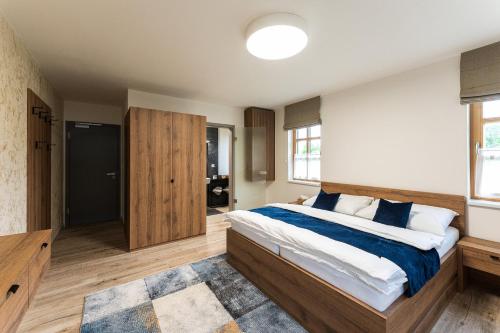 a bedroom with a large bed and a bathroom at Penzion Nad Pavlovem in Pavlov