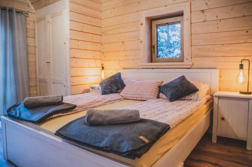 a bed in a log cabin with two pillows on it at Domek u Cianka w Kościelisku in Kościelisko