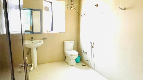 a small bathroom with a toilet and a sink at Red orchid farm in Gurgaon