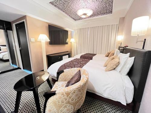 名古屋市にあるアパホテル 名古屋栄のベッドと椅子付きのホテルルーム