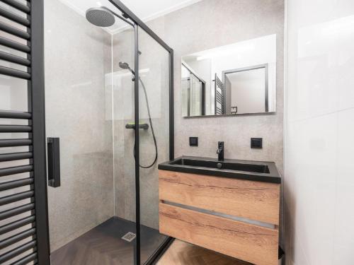 La salle de bains est pourvue d'un lavabo et d'une douche. dans l'établissement House with three bathrooms, on a holiday park, à Nieuw-Loosdrecht