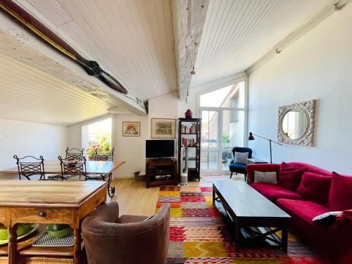 un salon avec un canapé rouge et une table dans l'établissement Bordeaux Terrace, à Bordeaux