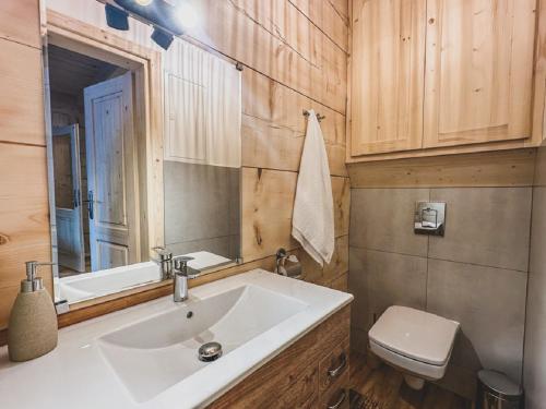 a bathroom with a sink and a toilet and a mirror at Domek u Cianka w Kościelisku in Kościelisko