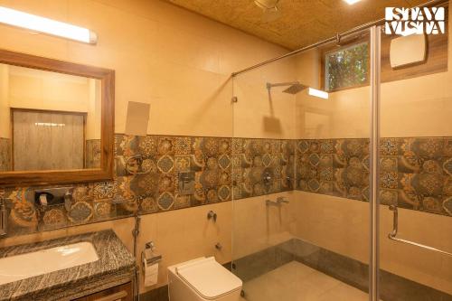a bathroom with a shower and a toilet and a sink at StayVista's Apple Farms - Urban Oasis with Outdoor Pool & Expansive Lawn in Sohna