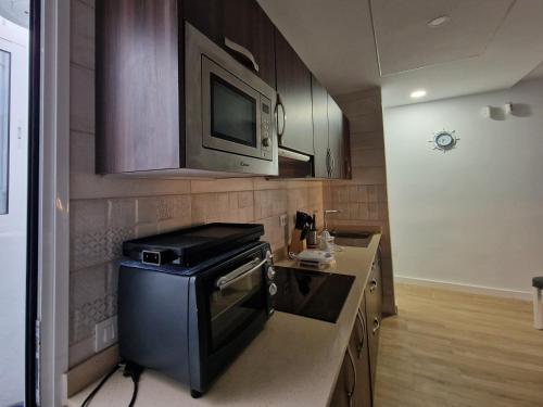 a kitchen with a stove and a microwave at MALVASIA 5 in Famara
