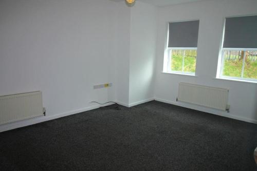an empty room with two windows and white walls at Arlington Court Apartment in Washington