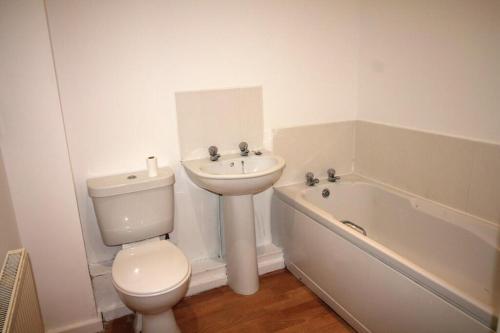 La salle de bains est pourvue de toilettes, d'un lavabo et d'une baignoire. dans l'établissement Arlington Court Apartment, à Washington