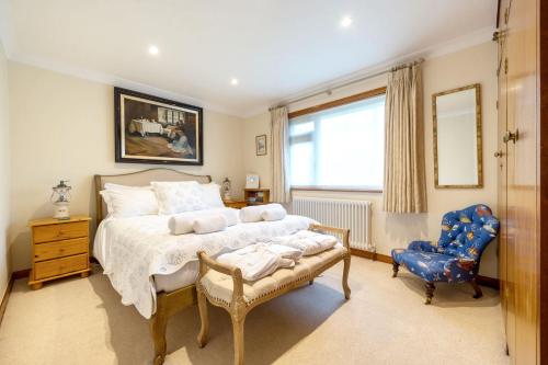 a bedroom with a large bed and a blue chair at High quality detached house with parking St. Ives in St Ives