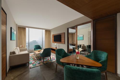 a living room with green chairs and a table at Fortune Park, East Delhi - Member ITC Hotels' Group in New Delhi