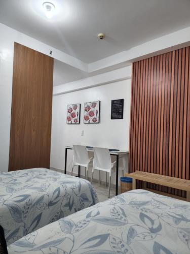 a room with two beds and a table and chairs at Flat 308 in Teresina