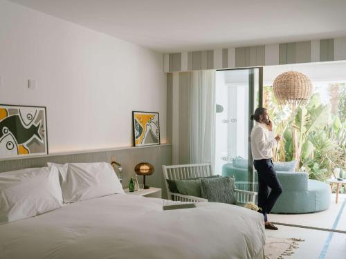 a woman talking on a cell phone in a bedroom at Hotel Sofitel Agadir Thalassa Sea & Spa in Agadir