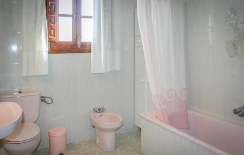 La salle de bains est pourvue de toilettes roses et d'un lavabo. dans l'établissement Villa Almenara, à Corumbela