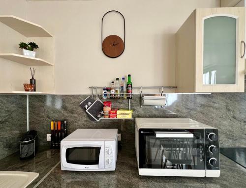 a kitchen counter with a microwave and a sink at PETIT CAPUCIN in Carcassonne