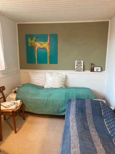 a bedroom with a bed and a painting of a giraffe at Lises bed and breakfast in Svendborg