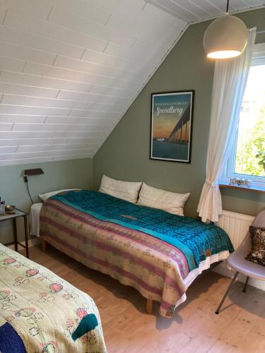 a bedroom with a bed and a window at Lises bed and breakfast in Svendborg