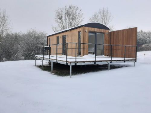 a tiny house in the snow with a deck at Au p'tit pré des salers in Hamois