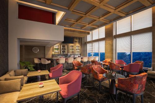 a restaurant with colorful chairs and tables and windows at Fortune Park, East Delhi - Member ITC Hotels' Group in New Delhi