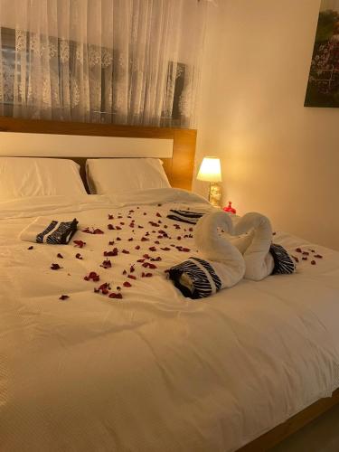 a white swan laying on a bed with roses on it at צימר אלין בכפר in Kiryat Ekron