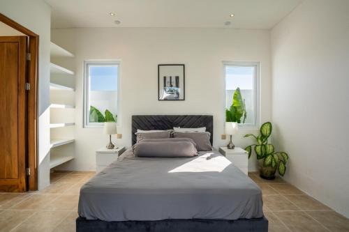 um quarto com uma cama grande e 2 janelas em Eden Cemagi Villa Mengwi em Mengwi