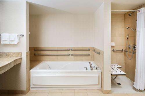 a bathroom with a white tub and a shower at Hilton Garden Inn Schaumburg in Schaumburg