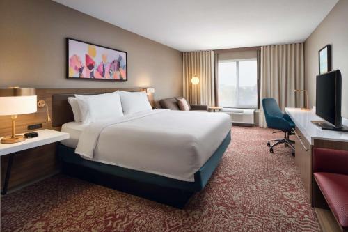 a hotel room with a large bed and a television at Hilton Garden Inn Schaumburg in Schaumburg