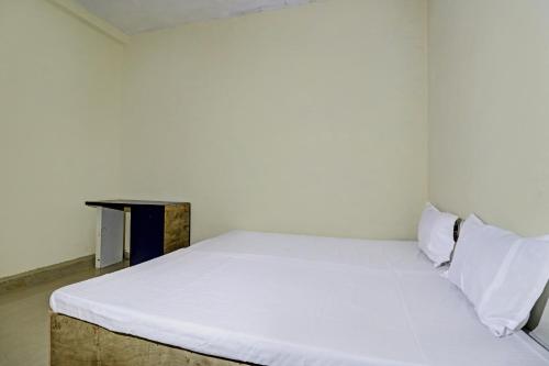 a white bed in a room with a table at SPOT ON 81062 Moonlight Hotel in Bhilai