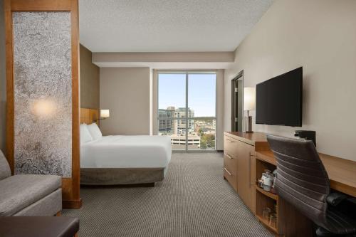 ein Hotelzimmer mit einem Bett und einem Flachbild-TV in der Unterkunft Hyatt Place Iowa City Downtown in Iowa City