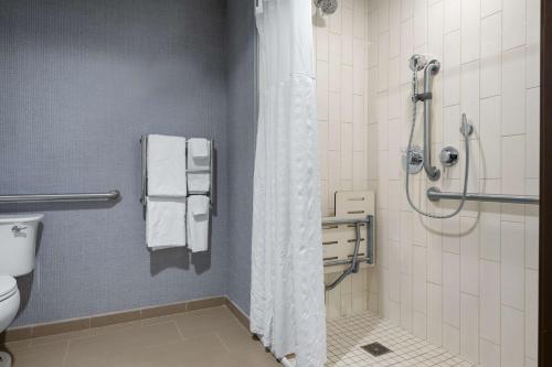 a bathroom with a shower and a toilet at Hyatt Place Iowa City Downtown in Iowa City