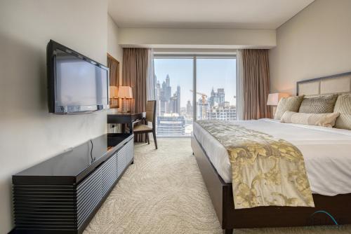 a hotel room with a bed and a flat screen tv at Posh 1BR at The Address Residences Dubai Marina by Deluxe Holiday Homes in Dubai