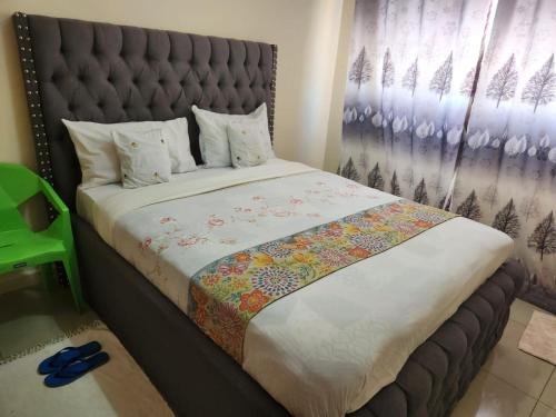 a bedroom with a large bed with a padded headboard at Prime Homes in Eldoret