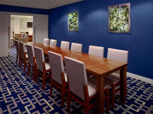 a dining room with a wooden table and chairs at Sonesta ES Suites Somerset in Somerset