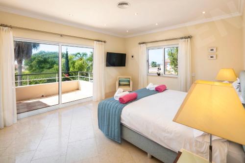 - une chambre avec un grand lit et un balcon dans l'établissement Villa Eden, à Carvoeiro