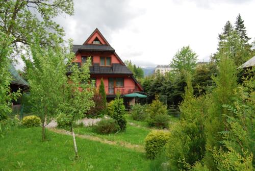 a red house in the middle of a yard at Willa Pod Banderą in Zakopane