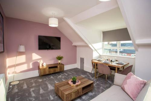 a living room with a table and a couch at Vacant Nests North Parade in Whitley Bay