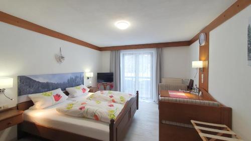 ルーポルディングにあるHotel Garni Haus Alpine - Chiemgau Karte inklのベッドルーム1室(ベッド1台、デスク、ベッドサイドシックスシックス付)