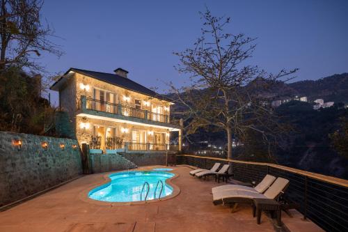 a house with a swimming pool in front of a house at Salud by Dacations with Heated Pool in Kasauli