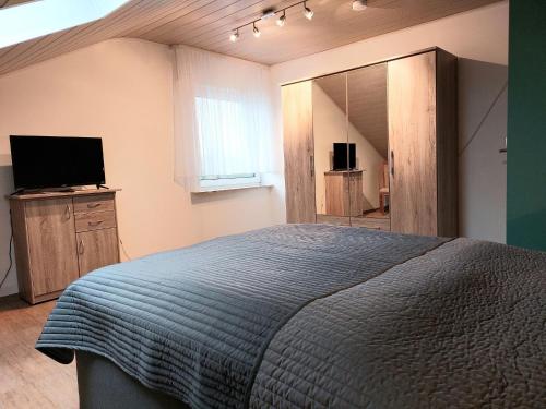PöhldeにあるCozy holiday apartment in the Harzのベッドルーム(大型ベッド1台、テレビ付)