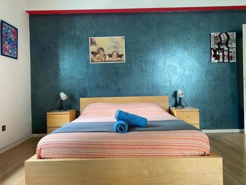 una camera con un letto con una parete blu di Comfortable and Friendly Apartment a Trieste