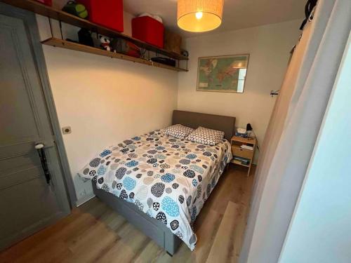 une chambre avec un lit avec une couette dessus dans l'établissement Appartement/Gobelins, à Paris