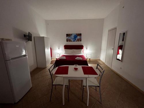 パレルモにあるAl Cortilettoのベッド、テーブル、椅子が備わる客室です。