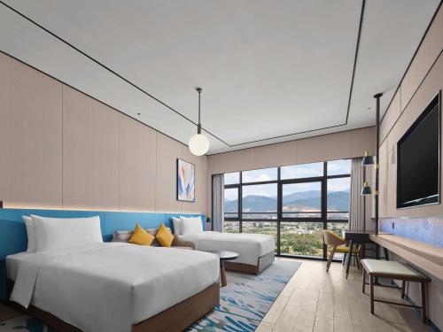 een hotelkamer met een bed en een televisie bij Hilton Garden Inn Ganzhou Longnan in Longnan