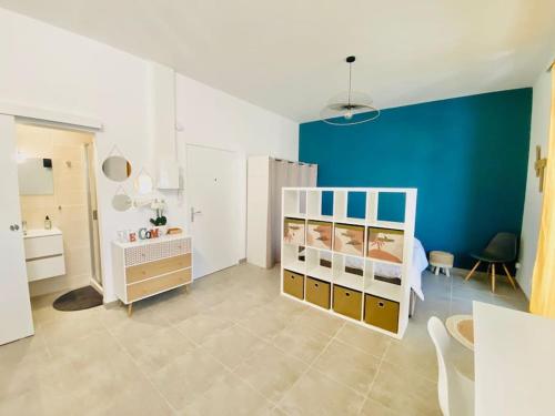 1 dormitorio con cama y pared azul en Grand studio pour 2 Perpignan Bir Hakeim, en Perpiñán
