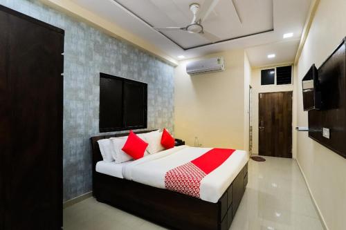 um quarto com uma cama com almofadas vermelhas em Hotel Sunrise em Naroda