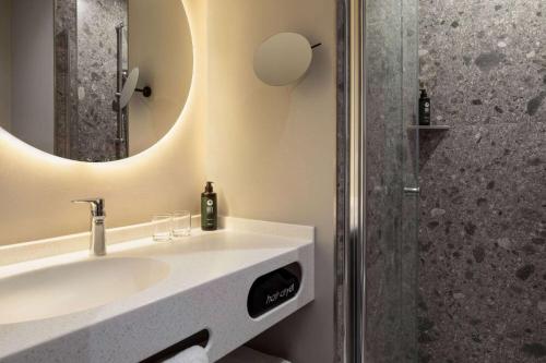 a bathroom with a sink and a shower at Vienna House Easy by Wyndham Berlin Potsdamer Platz in Berlin